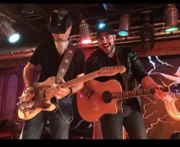 Dino and Mark performing together and laughing on stage