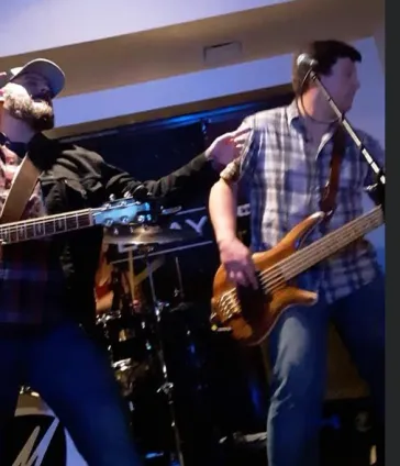 Mark and Tom performing on stage with blue stage lighting