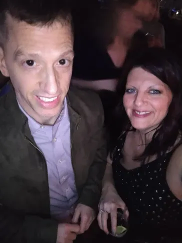 Two fans smiling together at an indoor show