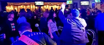 Fans dancing on a balcony at an indoor venue