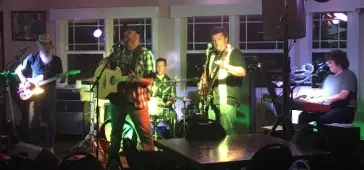 Dino playing guitar with a fan dancing at a campaign event