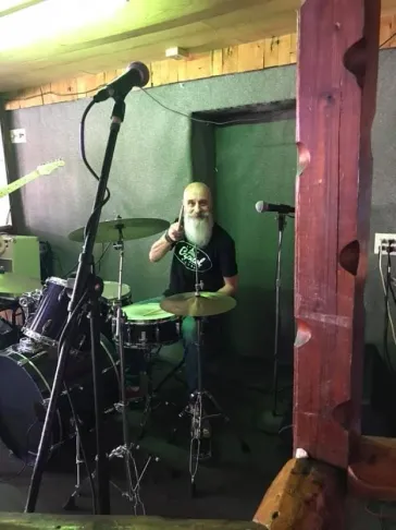 Mark performing on stage at a small indoor venue