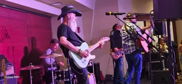 Band performing live with purple lighting