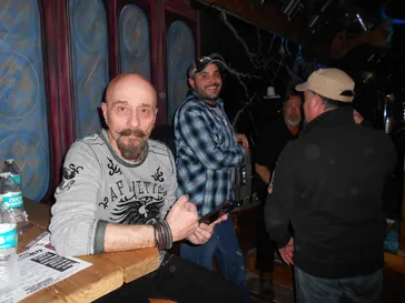Fans relaxing at a bar table at an indoor venue