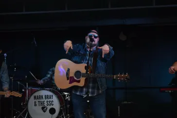 Mark Bray performing with acoustic guitar