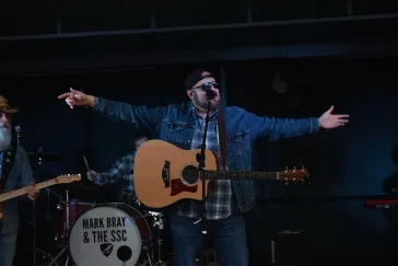 Mark Bray performing with arms wide open