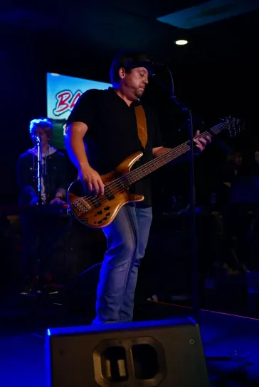 Tom on bass under blue stage lighting