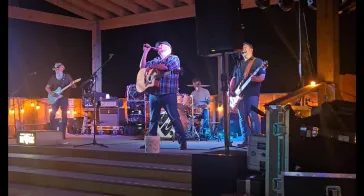 Full band performing on outdoor stage