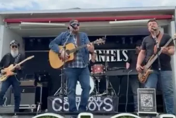 Full band performing outdoors at Daniels