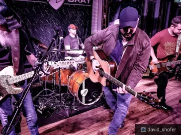 Band performing with Dino and Mark on guitars