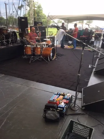 Drummer setting up on outdoor stage