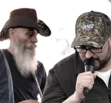 Two musicians with microphone at outdoor event