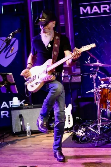 Dino shredding white telecaster under purple stage lights