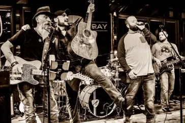 Full band performing in sepia tone at Mark Bray venue