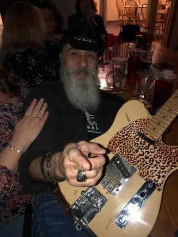 Dino with leopard print telecaster at a gathering