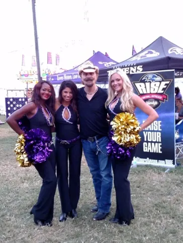 Mark with Baltimore Ravens cheerleaders at an outdoor event