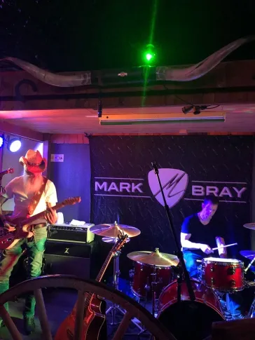 Dino playing guitar with a fan dancing on stage