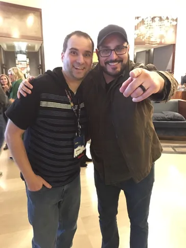 Two friends posing together at a music event