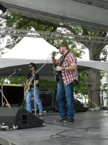 Mark and Dino performing on outdoor stage under pergola