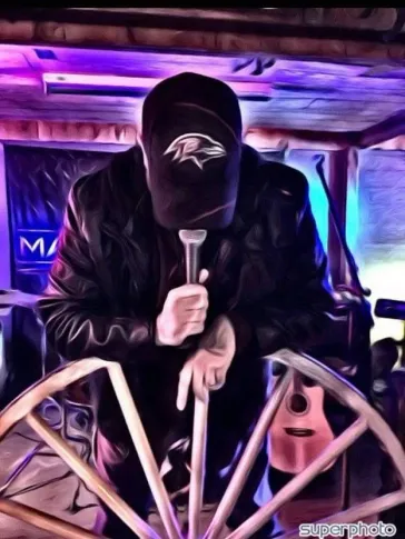 Mark performing at the Mark Bray venue with Ravens cap and wagon wheel
