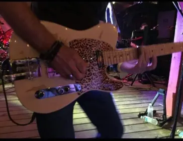 Close-up of Dino playing leopard print telecaster on stage